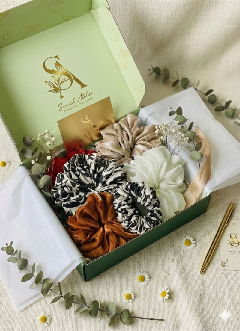 Set of hair accessories in a decorative box on a light fabric background